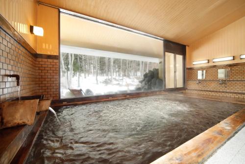 a pool of water in a bathroom with a large window at Oribana in Omachi