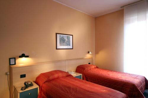 a hotel room with two beds and a window at Residence Pian della Nave in Milan