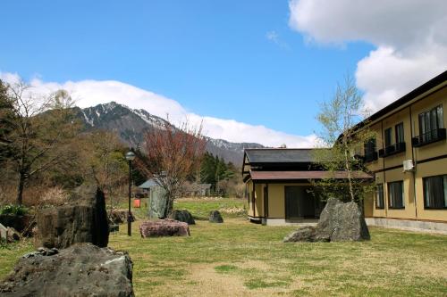 a building with rocks in the grass next to a building at Oribana in Omachi