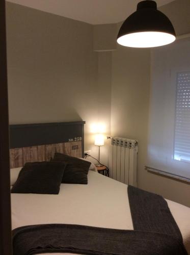 a bedroom with a large bed and a lamp at Hotel Rural Valle San Emiliano in San Emiliano