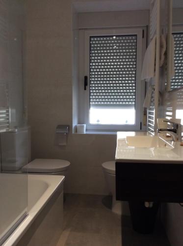 a bathroom with a sink and a toilet and a window at Hotel Rural Valle San Emiliano in San Emiliano