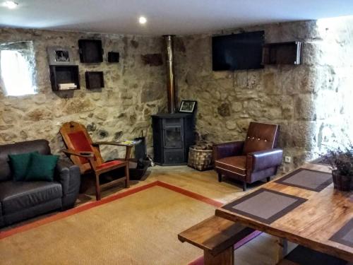 a living room with furniture and a stone wall at Albergue Casa do Sardão in Carreço