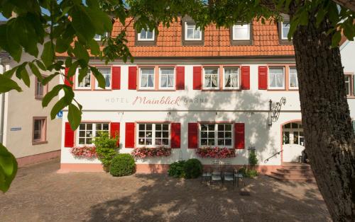 マルクトハイデンフェルトにあるHotel Mainblick Garniの赤白の縁取りと木の建物