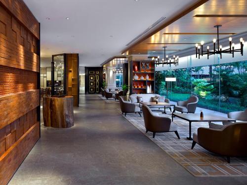 a lobby of a hotel with tables and chairs at Shangri-La Jakarta in Jakarta