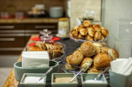 ein Tisch voller Teller mit Brot und Schüsseln mit Gebäck in der Unterkunft Hotel Murowanica in Zakopane