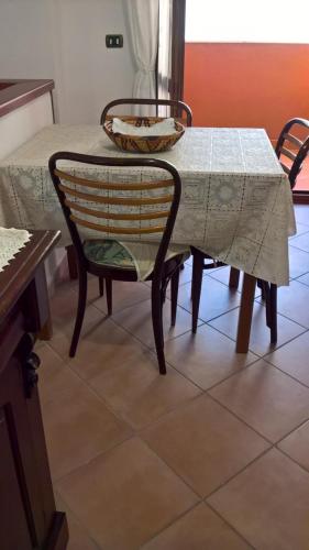 a table and a chair with a white table cloth on it at Appartamento Tulipano in Alghero