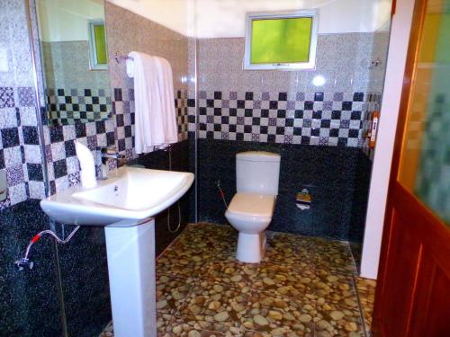 a bathroom with a toilet and a sink and a shower at Amour Surf in Tangalle