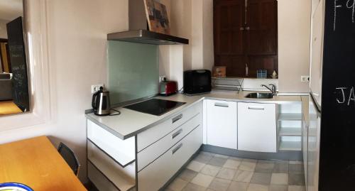 a small kitchen with white cabinets and a sink at 19th Century Sevillian Apartment in Seville