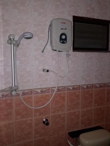 a shower head in a bathroom with a toilet at Tanjung Demong Beach Resort in Kuala Besut