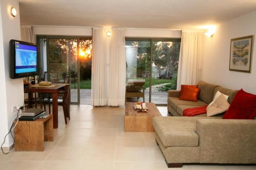 a living room with a couch and a tv at Above the Sea in ‘En Hod