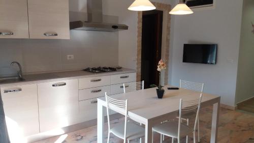 a kitchen with a table and chairs and a tv at Casa Vacanze Spadafora 2 in Spadafora