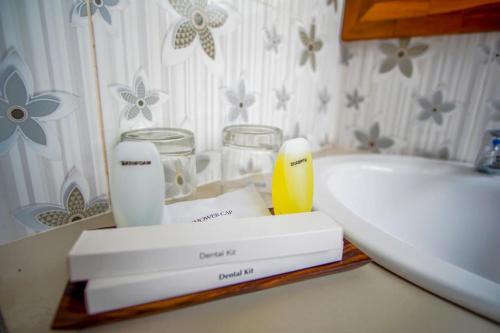 a bathroom counter with a sink and a bath tub at Kutuh Manak Guest House in Uluwatu