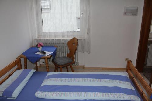 a bedroom with a bed and a table and a window at Gasthaus Mösle in Reute
