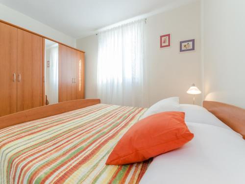 a bedroom with a bed with an orange pillow at Holiday house Mareta, Sea View in Dragove