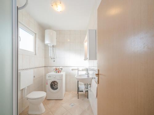 a bathroom with a washing machine and a sink at Holiday house Mareta, Sea View in Dragove