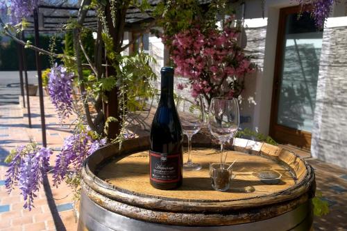 a bottle of wine and two glasses on a barrel at Logis Hotel Le Nouvel in Portes-lès-Valence