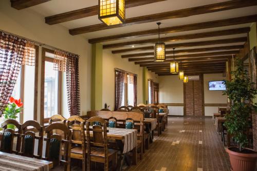 a dining room with tables and chairs and windows at Hotel & Restaurant Complex HAP-OK in Brodki