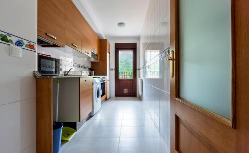 a kitchen with a door leading to a hallway at Apartamentos El Caxigu in Arenas de Cabrales