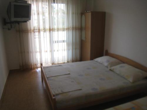 a bedroom with a large bed with a window at Apartments Circle Olive in Ulcinj