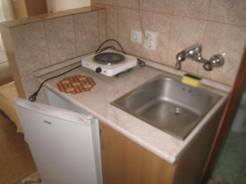 a small kitchen with a sink and a stove at Apartments Circle Olive in Ulcinj