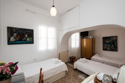 a room with two beds and a window at Hotel Delphines in Mikonos