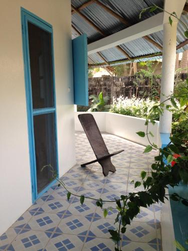 a porch with a chair on a tiled floor at Guesthouse Yonol in Abene