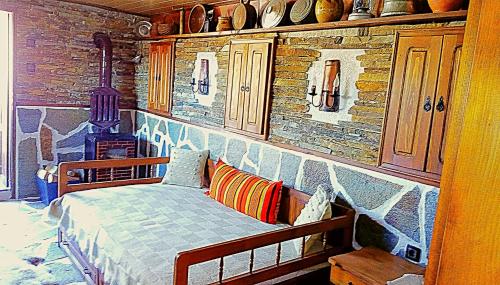 Un dormitorio con una cama y una pared de piedra. en Villa Rupcovoto, en Smolyan
