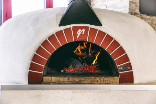 a brick oven with a fire in it at LOFTSTYLE Hotel Gerlingen, Sure Hotel Collection by Best Western in Gerlingen