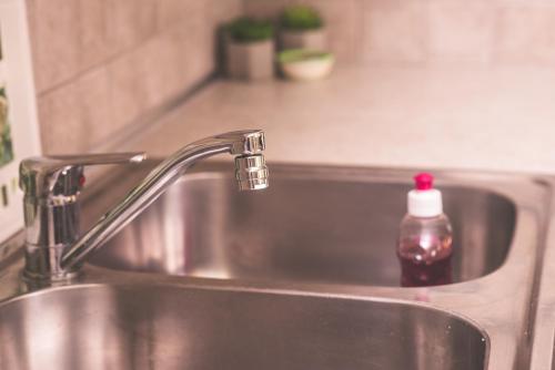 a kitchen sink with a soap bottle sitting on it at Nefeli City Apartments in Patra