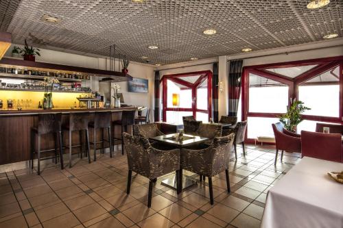 a restaurant with a bar and tables and chairs at LOFTSTYLE Hotel Gerlingen, Sure Hotel Collection by Best Western in Gerlingen