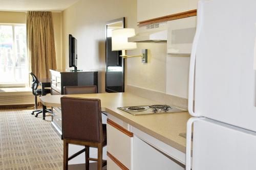 a kitchen with a counter and a table with chairs at Extended Stay America Select Suites - Orlando - Southpark - Equity Row in Orlando