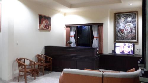 a living room with a couch and a piano at Hotel Mawar Sari Mitra RedDoorz in Payangan