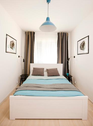 a white bed in a bedroom with a window at Heaven in Hel 1 in Hel