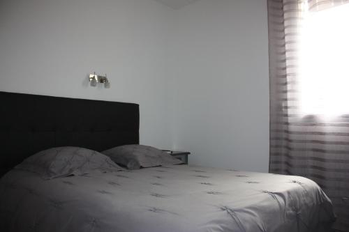 A bed or beds in a room at Hôtel le midi