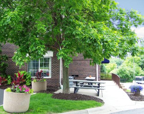 a picnic table under a tree in front of a brick building at Extended Stay America Suites - Minneapolis - Eden Prairie - Technology Drive in Eden Prairie