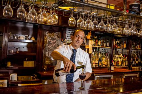 a man pouring a glass of wine in a bar at Royal Plaza Hotel in Tiberias