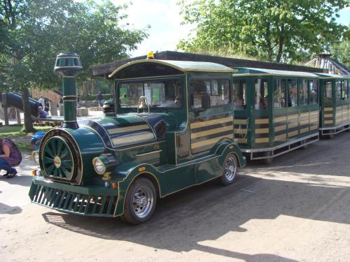 an old green train car parked in a parking lot at Best Western Plus Hotel Fredericia in Fredericia