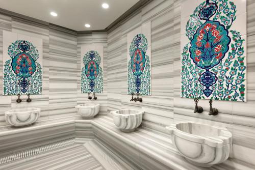a bathroom with three sinks and stained glass windows at Trip Bosphorus Taksim Hotel in Istanbul