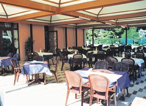 un grupo de mesas y sillas con mesas y registradores en Residence Joker, en Cavallino-Treporti