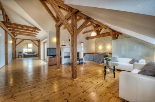 una gran sala de estar con techos de madera y suelos de madera. en Residence St Havel Prague Old Town, en Praga