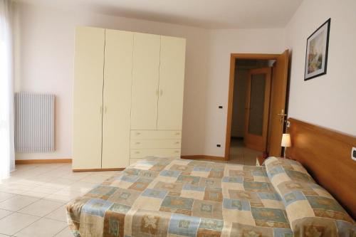 カヴァッリーノ・トレポルティにあるAppartamenti Joker Vallenovaのベッドルーム1室(大型ベッド1台、キャビネット付)