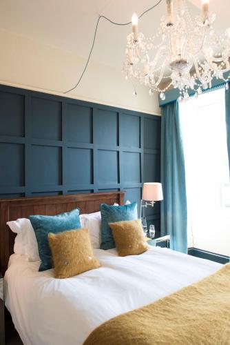 a bedroom with a large bed with a blue wall at The Priory in Middleham