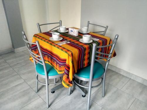 a table with two chairs and a colorful table cloth at Kelebek Hostel in Lima