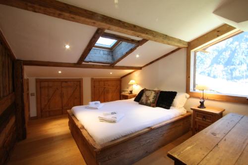 夏慕尼白朗峰的住宿－Chalet Martinique - Chamonix All Year，一间卧室设有一张床和一个大窗户