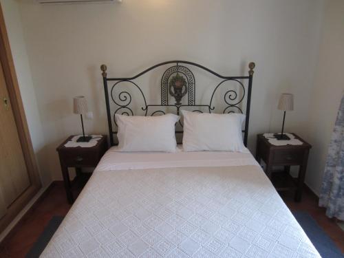 Casa do vale das Hortas في Balurco de Baixo: غرفة نوم بسرير كبير مع مواقف ليلتين