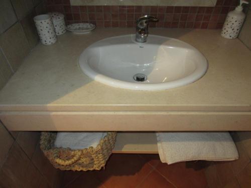 un lavabo blanco en el baño con toallas. en Casa do vale das Hortas, en Balurco de Baixo