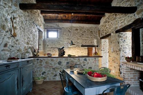 a kitchen with a table with a bowl of fruit on it at Residenza d'Epoca Borgodifiume in Fiumefreddo Bruzio