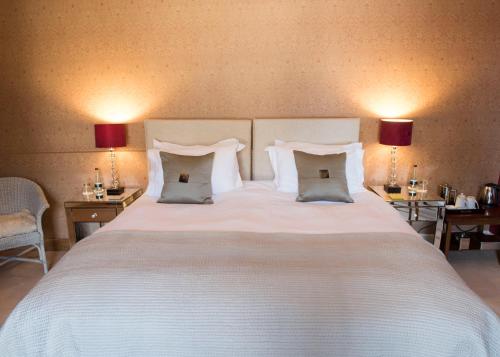a large white bed with two tables and two lamps at The Priory in Middleham