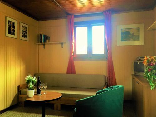 a living room with a couch and a table and a window at Camping Hotel Au Lac De Como in Sorico