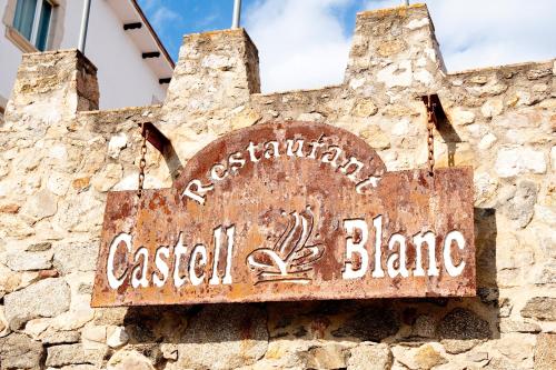 an old sign on the side of a stone building at Hotel Castell Blanc in Empuriabrava